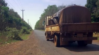 Eski bir küçük tank kamyona arkadan görünüm yolu ile lateks sap ile dolu