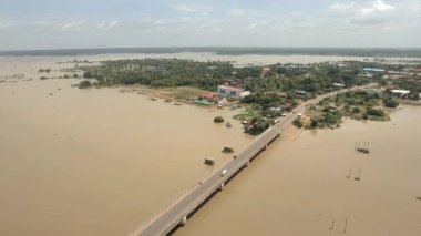 Hava dron vurdu: kırsal alan sular altında nehri geçip çalıştıran geri beton köprü üzerinde uçan. Köy içinde belgili tanımlık geçmiş