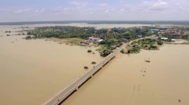 Hava dron vurdu: kırsal alan sular altında nehri geçip çalıştıran bir beton köprü üzerinde uçan. Köy içinde belgili tanımlık geçmiş