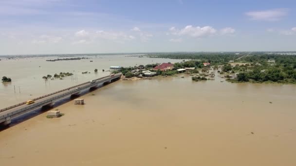 空中无人机射击 飞越一座混凝土桥梁 穿过淹没在农村地区的河流 背景村 — 图库视频影像
