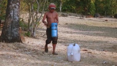 Bir palmiye ağacı hasat palm sap sonra tırmanma toddy uzantılar. Hedefe yönlendirmeye taze hasat palm sap plastik bidon içine dostum
