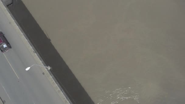 Luftaufnahme Rückwärts Fahrender Fahrzeuge Über Eine Straßenbrücke Über Einen Fluss — Stockvideo