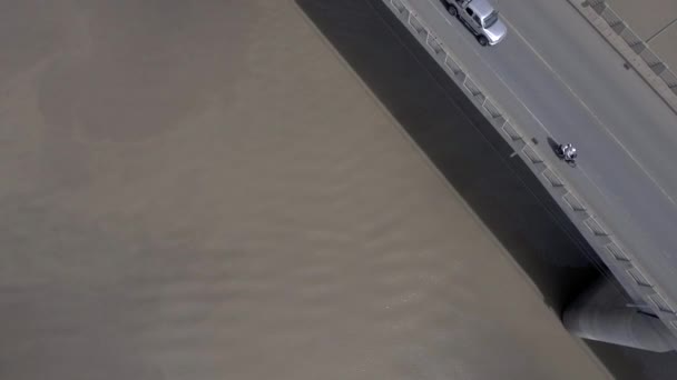 Vue aérienne des véhicules arrière traversant un pont routier au-dessus d'une rivière (journée ensoleillée)  )