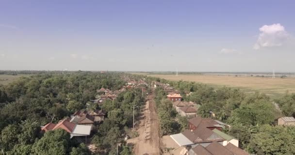 ショット空中ドローン 農村から未舗装の道路に乗って自転車で飛び — ストック動画