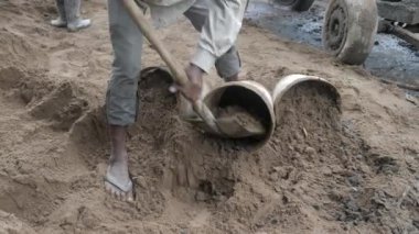 Kum bir kova içine koymak için bir kürek kullanarak (yakın)