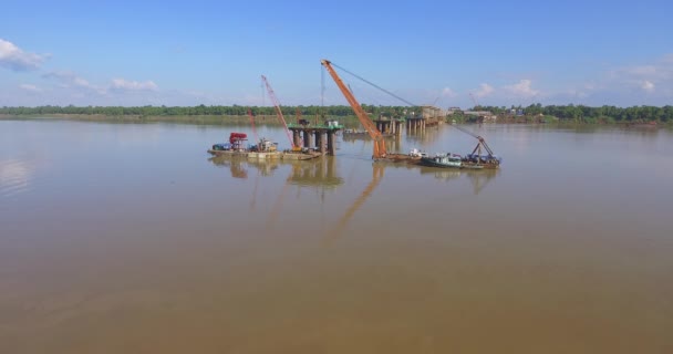 空中射击 飞向桥梁基础和驳船安装起重机在河里 — 图库视频影像