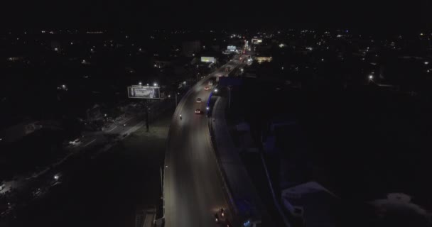 ショット空中ドローン 夜の町で橋を渡って車で飛び — ストック動画