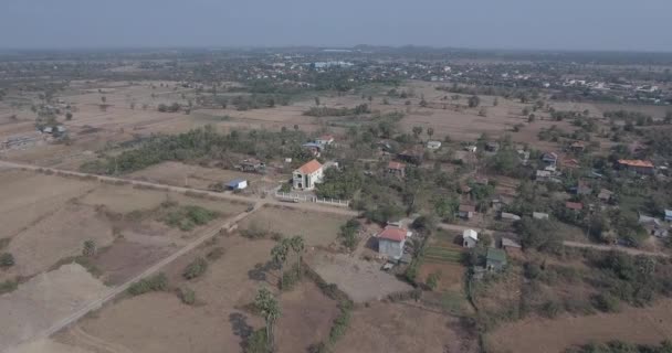 空中无人机射击 飞越干燥田野周围的一个小村庄 — 图库视频影像