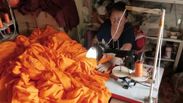 女人用缝纫机为僧人做橙色长袍 — 图库视频影像
