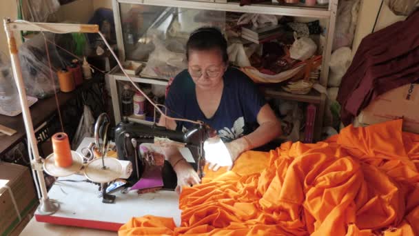 Женщина Делает Оранжевый Халат Монаха Используя Швейную Машинку — стоковое видео