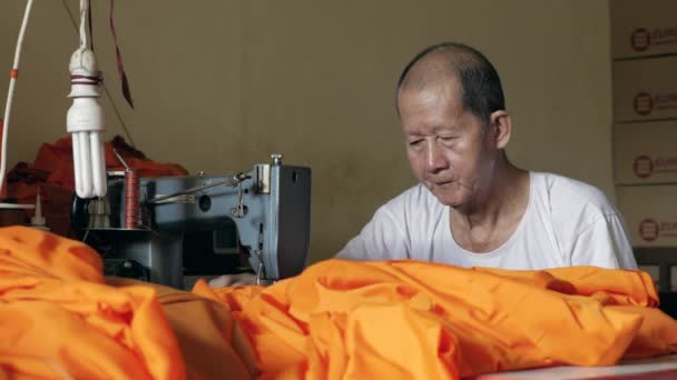 Old Man Making Orange Robe Monk Using Sewing Machine — Stock Video