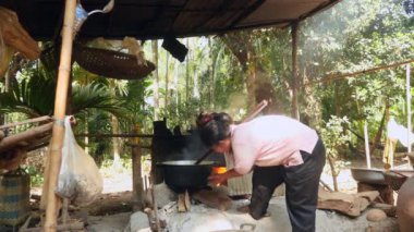 Yeşil fasulye bir ahşap stick kullanarak bir tencereye karıştırarak kadın