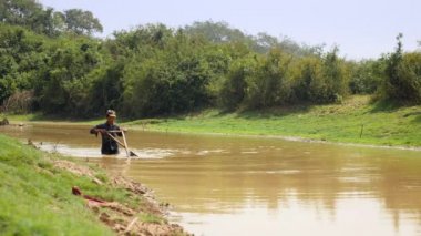 fisher nerede istiridye yakalanırlar göl kumlu alt üzerinde sürüklemek için bir itme sepeti kullanarak. Üçgen hasır sepet iki parçaya bölünmüş bir bambu direk bağlı olduğu. 
