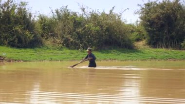 fisher nerede istiridye yakalanırlar göl kumlu alt üzerinde sürüklemek için bir itme sepeti kullanarak. Üçgen hasır sepet iki parçaya bölünmüş bir bambu direk bağlı olduğu. 