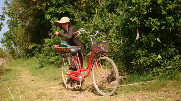 彼のバイクの荷物棚に弾性ロープで袋の中にいっぱいアサリを含む彼の竹かごを結ぶ女 — ストック動画