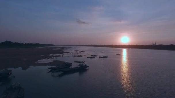 在日落时飞向返回 露出河上的一座竹桥 周围有游来游去的人的剪影 — 图库视频影像