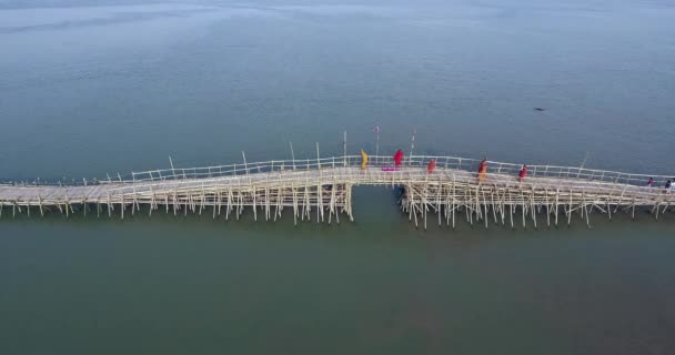 僧侶や川に架かる竹の橋を渡る人々 のグループの空中ショット — ストック動画
