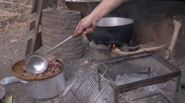 Domuz eti cracklings dışarı pot alarak ve bambu sepet içinde koyarak adam