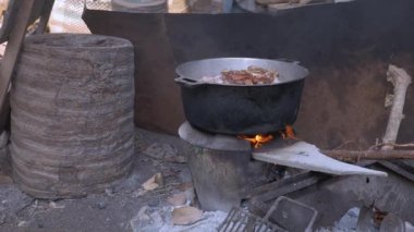 Bir yağ açık havada ev yapmak için domuz eti kaynar ve tahta bir sopa kullanma