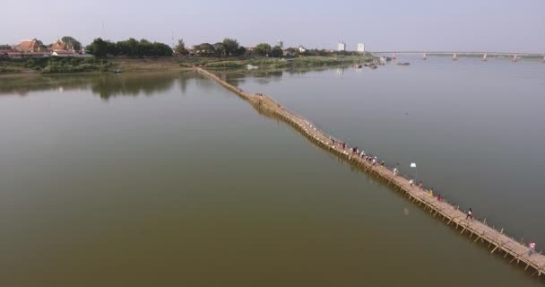 ショット空中ドローン 川に長い竹の橋を渡る人々 で飛び — ストック動画