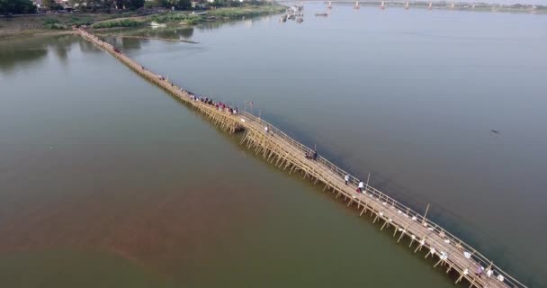 ショット空中ドローン 川に長い竹の橋を渡る人々 で飛び — ストック動画