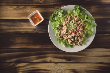 Ton balıklı salata ve koyu ahşap masa üzerinde chili Soslu sebze. Üstten görünüm.