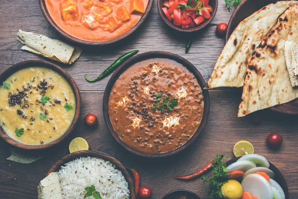Öğle veya akşam yemeği, pilav, mercimek, paneer, dal makhani, naan, Hint turşusu, çeşitli Hint Gıda moody arka plan üzerinde baharatlar. seçici odak