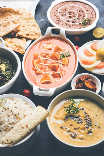 Öğle veya akşam yemeği, pilav, mercimek, paneer, dal makhani, naan, Hint turşusu, çeşitli Hint Gıda moody arka plan üzerinde baharatlar. seçici odak