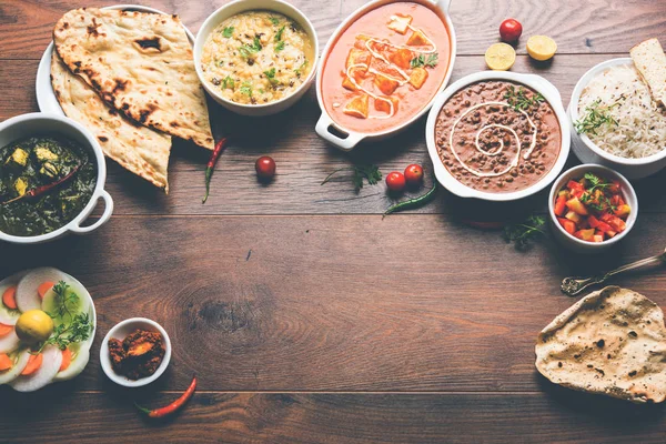 Öğle veya akşam yemeği, pilav, mercimek, paneer, dal makhani, naan, Hint turşusu, çeşitli Hint Gıda moody arka plan üzerinde baharatlar. seçici odak