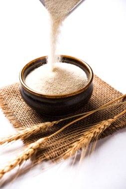 Ham İrmik unu veya Rava toz makarnalık buğday kaba, saflaştırılmış buğday yonca olduğunu. Düz arka plan üzerinde bir yığın olarak veya bir kase ya da kaşık servis. Seçici odak