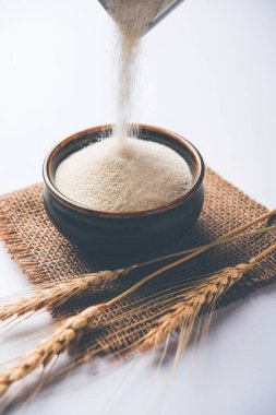 Ham İrmik unu veya Rava toz makarnalık buğday kaba, saflaştırılmış buğday yonca olduğunu. Düz arka plan üzerinde bir yığın olarak veya bir kase ya da kaşık servis. Seçici odak