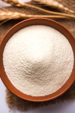 Ham İrmik unu veya Rava toz makarnalık buğday kaba, saflaştırılmış buğday yonca olduğunu. Düz arka plan üzerinde bir yığın olarak veya bir kase ya da kaşık servis. Seçici odak