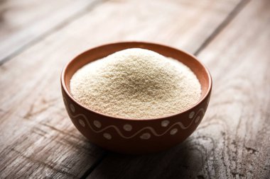 Ham İrmik unu veya Rava toz makarnalık buğday kaba, saflaştırılmış buğday yonca olduğunu. Düz arka plan üzerinde bir yığın olarak veya bir kase ya da kaşık servis. Seçici odak