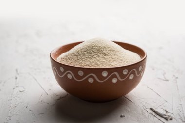 Ham İrmik unu veya Rava toz makarnalık buğday kaba, saflaştırılmış buğday yonca olduğunu. Düz arka plan üzerinde bir yığın olarak veya bir kase ya da kaşık servis. Seçici odak