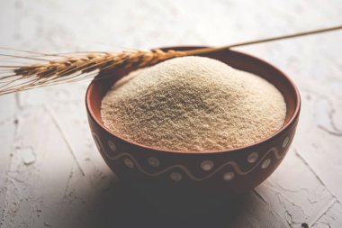 Ham İrmik unu veya Rava toz makarnalık buğday kaba, saflaştırılmış buğday yonca olduğunu. Düz arka plan üzerinde bir yığın olarak veya bir kase ya da kaşık servis. Seçici odak