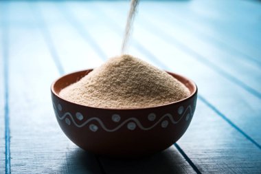 Ham İrmik unu veya Rava toz makarnalık buğday kaba, saflaştırılmış buğday yonca olduğunu. Düz arka plan üzerinde bir yığın olarak veya bir kase ya da kaşık servis. Seçici odak