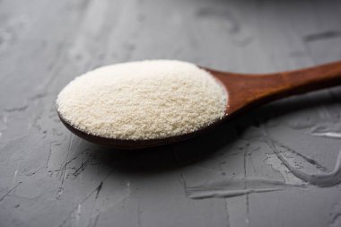 Ham İrmik unu veya Rava toz makarnalık buğday kaba, saflaştırılmış buğday yonca olduğunu. Düz arka plan üzerinde bir yığın olarak veya bir kase ya da kaşık servis. Seçici odak