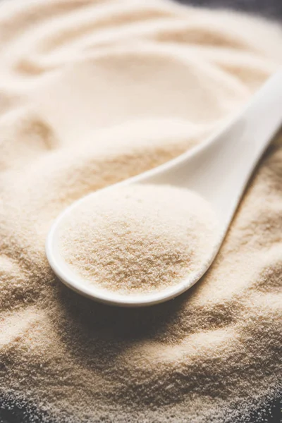 Ham İrmik unu veya Rava toz makarnalık buğday kaba, saflaştırılmış buğday yonca olduğunu. Düz arka plan üzerinde bir yığın olarak veya bir kase ya da kaşık servis. Seçici odak