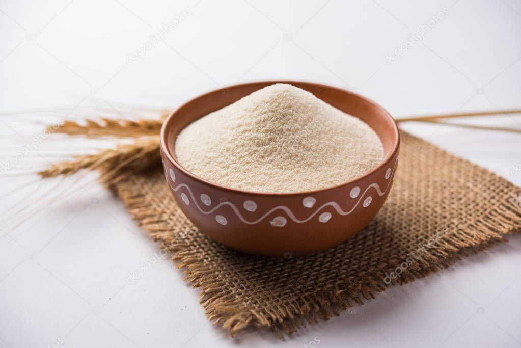 Raw Semolina flour or Rava powder is the coarse, purified wheat middlings of durum wheat. Served over plain background as a heap or in a bowl or spoon. Selective focus