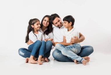 Genç Hintli aile beyaz arka planda izole bir şekilde oturuyor. seçici odak