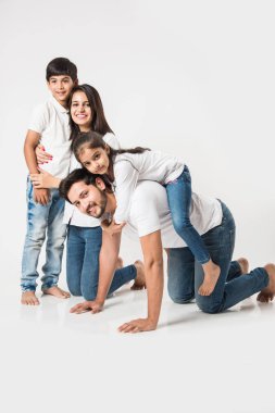 Mutlu kız babasının sırtına biniyor. Annem ve kardeşim gülerken Hintli küçük kız babamın sırtında oturuyor. seçici odak