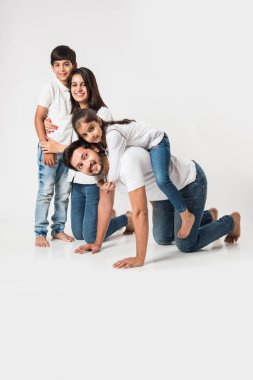 Mutlu kız babasının sırtına biniyor. Annem ve kardeşim gülerken Hintli küçük kız babamın sırtında oturuyor. seçici odak