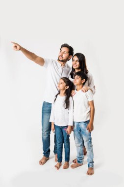 Babam beyaz arka planda karısı ve çocuklarıyla dikilirken parmağıyla işaret ediyor. seçici odak