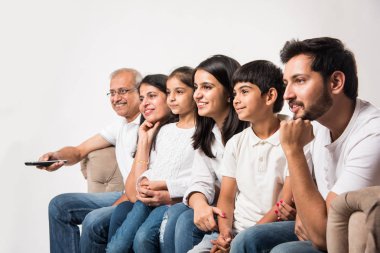 Çok nesildir Hintli ya da Asyalı aileler evde televizyon izlerken koltukta oturuyorlar, seçici bir odaklanma.