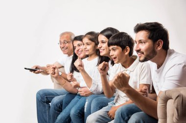 Çok nesildir Hintli ya da Asyalı aileler evde televizyon izlerken koltukta oturuyorlar, seçici bir odaklanma.