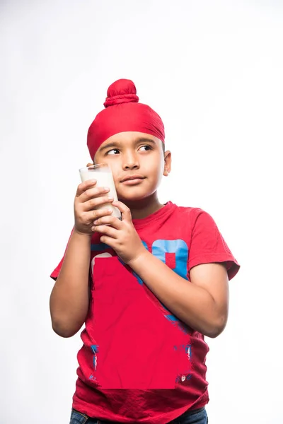 Sikh 旁遮普小男孩拿着满满一杯牛奶 被隔离在白色背景 — 图库照片