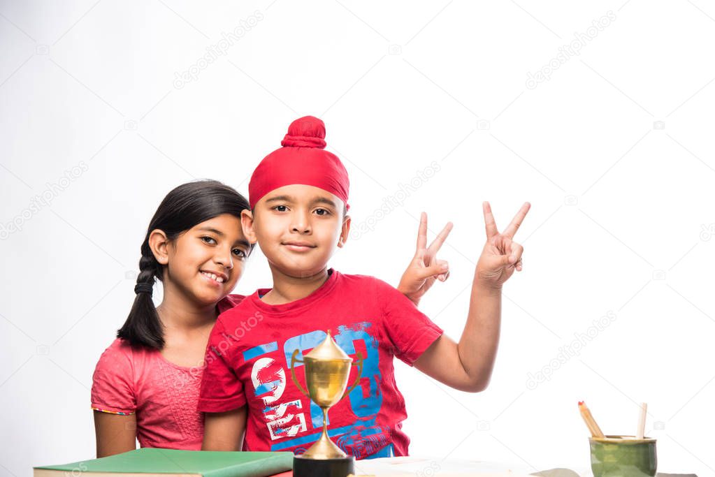 small Indian/sikh boy studying at study table with books