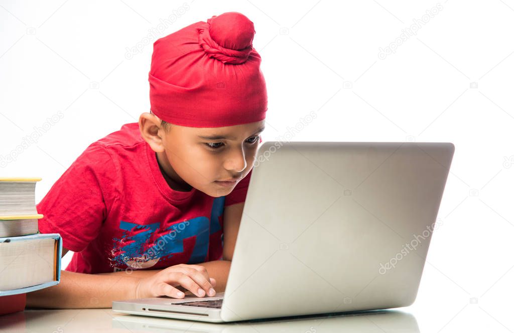 Sikh Indian kid/boy studying using laptop or playing games