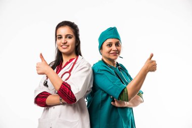 İki kadın doktor ya da cerrah ayakta kameraya bakıyor.