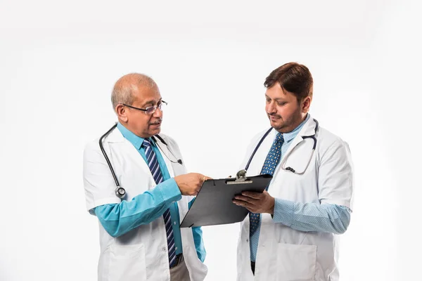 Two Indian Male Doctors Discussing Medical Case Chart Standing Isolated Stock Image